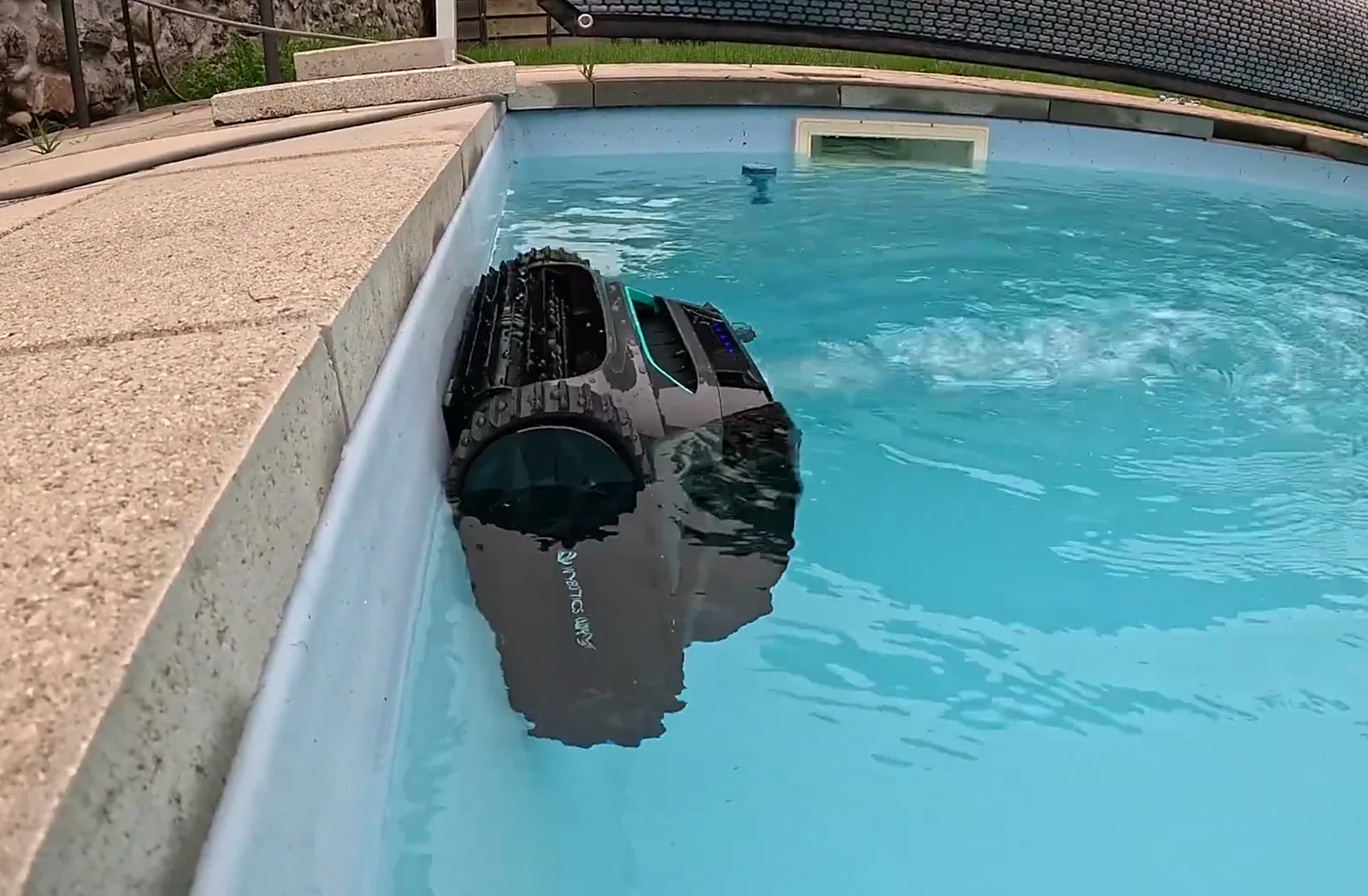 Le Wybot S2 grimpe la paroi d'une piscine à moitié sorti de l'eau pendant le test