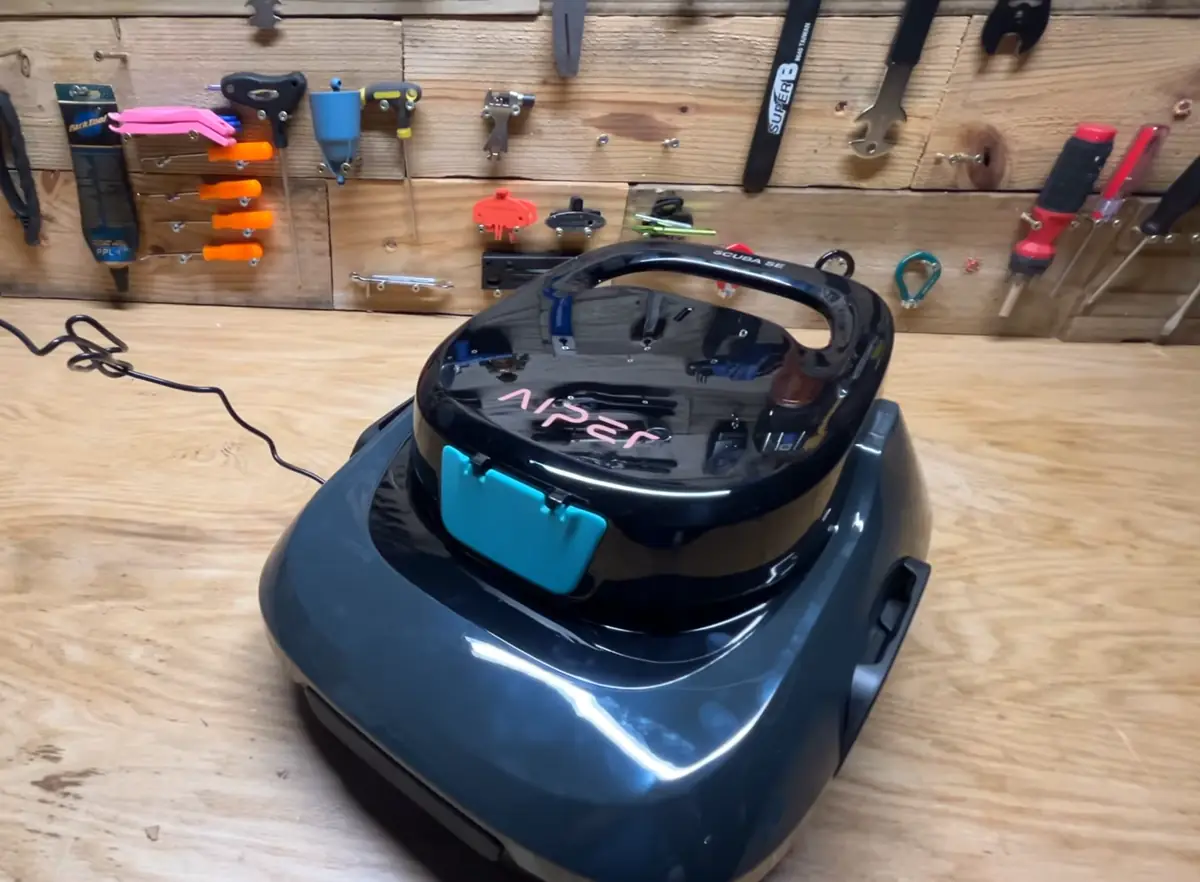 Aiper Scuba SE posé sur l'établi, chargeur branché sur la prise arrière