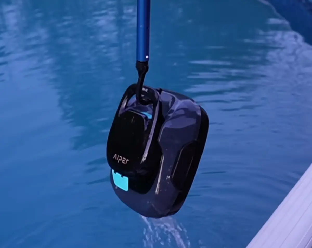 L'Aiper Scuba SE remonté hors de l'eau à l'aide du crochet fixé sur un manche télescopique