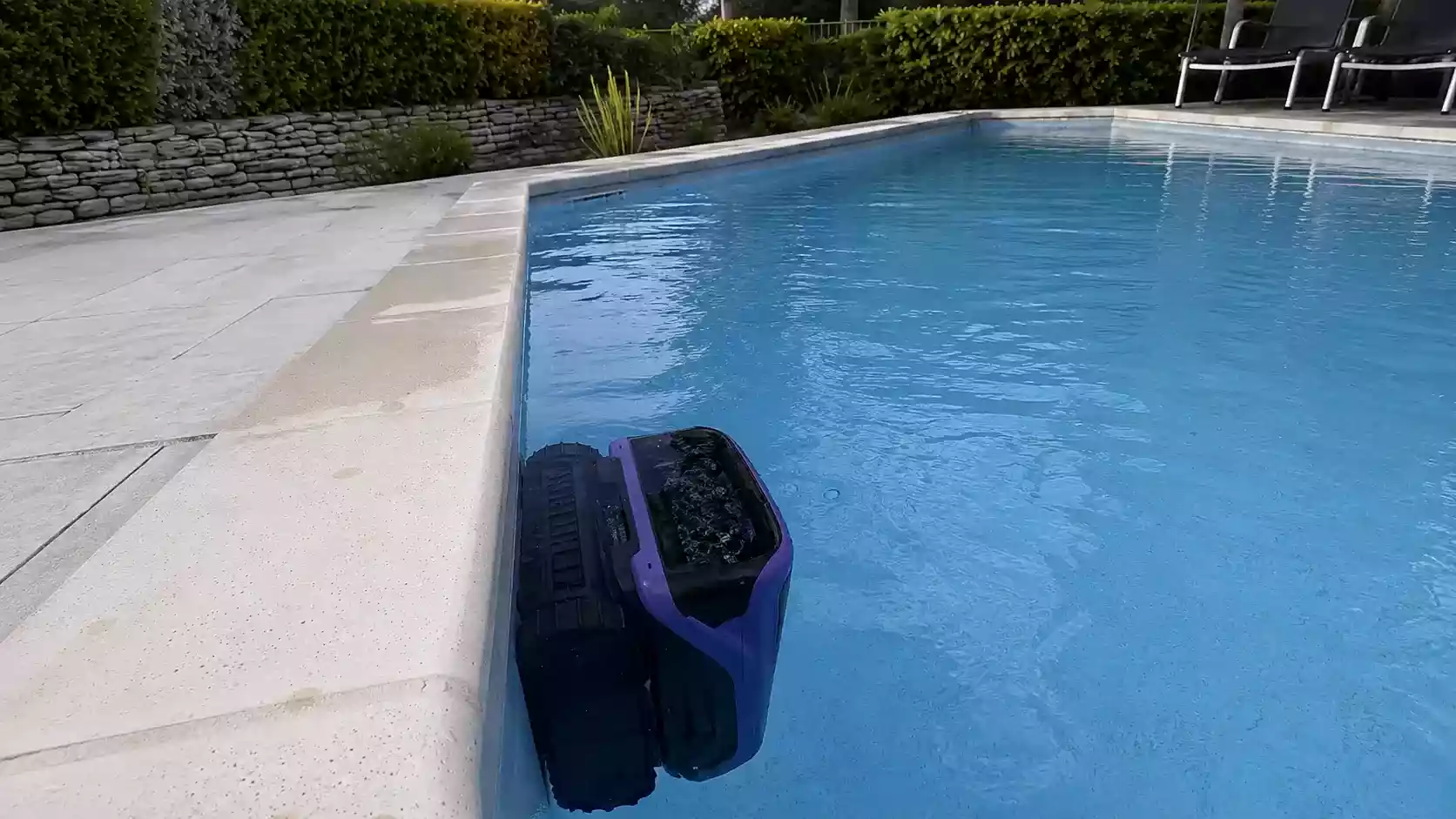 Beatbot Sora 70 grimpant sur la paroi verticale d'une piscine pour nettoyer la ligne d'eau à côté du skimmer