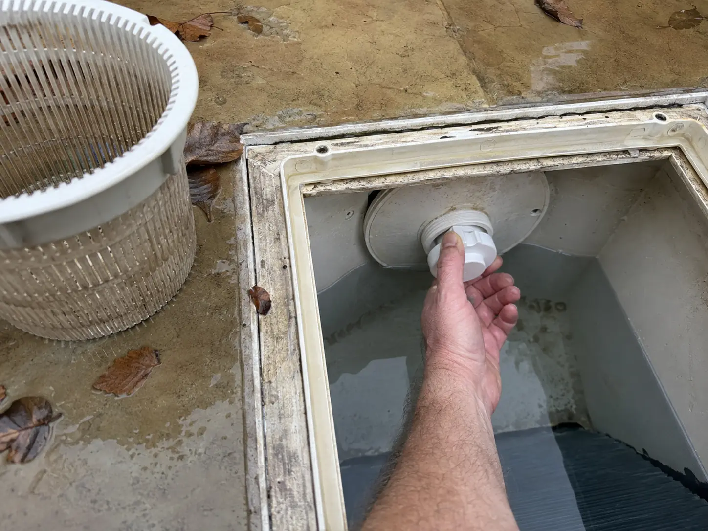 Bouchon d'hivernage vissé dans le skimmer d'une piscine, panier retiré