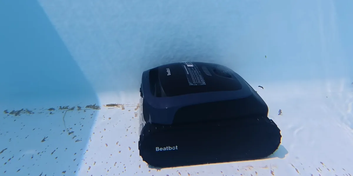 Le Beatbot AquaSense 2 au fond d'un bassin chargé de débris