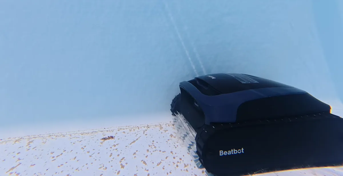 Le Beatbot AquaSense 2 en pleine remontée de paroi, débris encore présents au fond