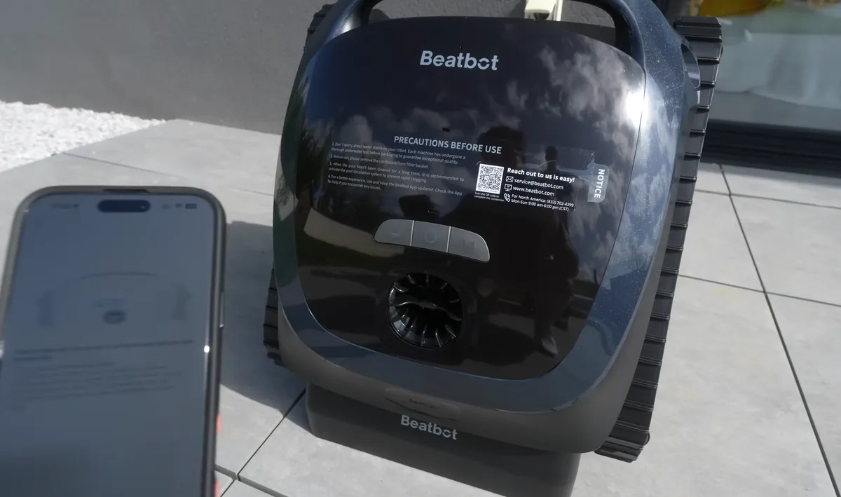 Le Beatbot AquaSense 2 posé sur son socle de charge à induction au bord du bassin