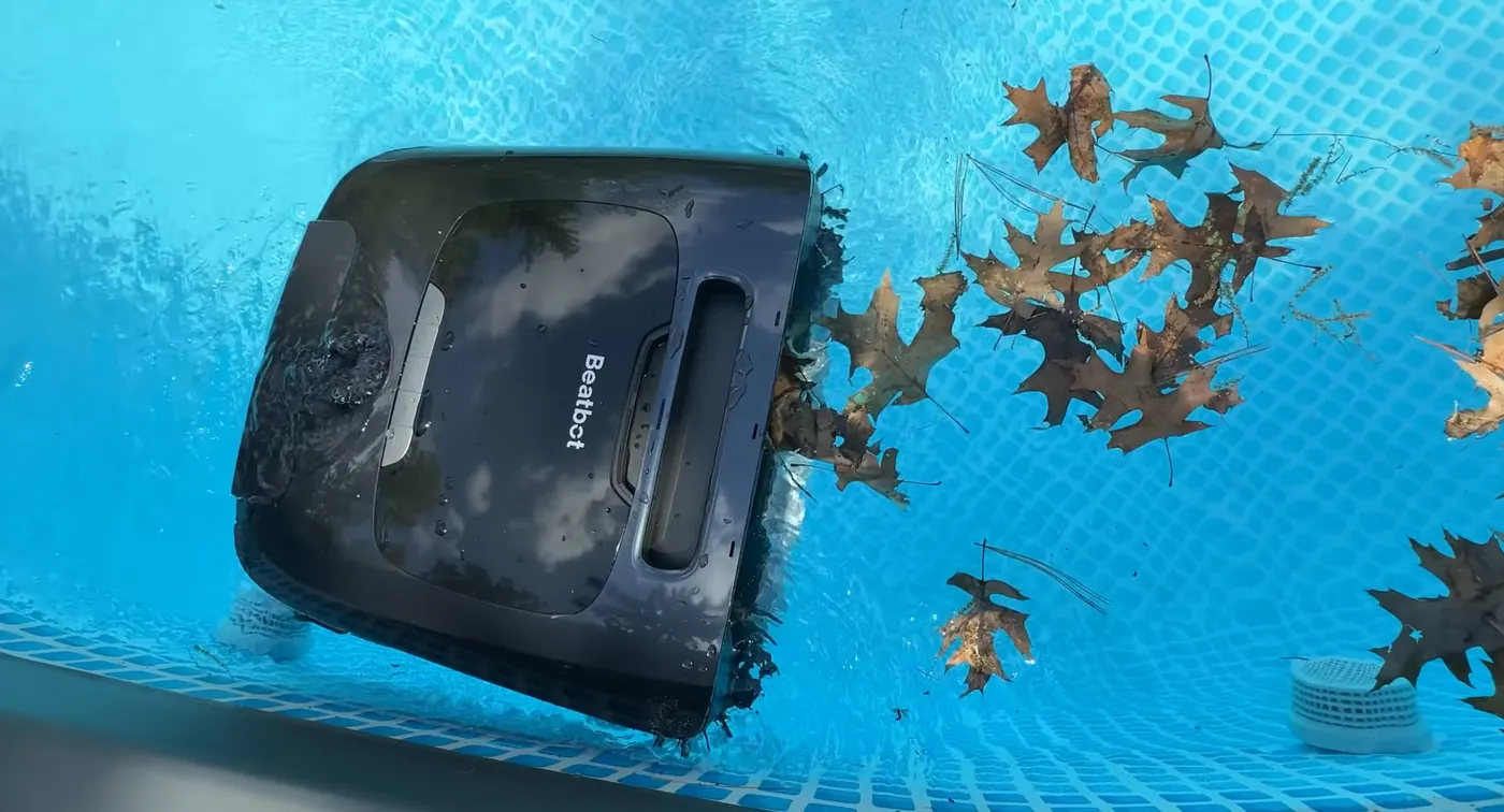 Beatbot AquaSense 2 Ultra à la ligne d’eau parmi des feuilles