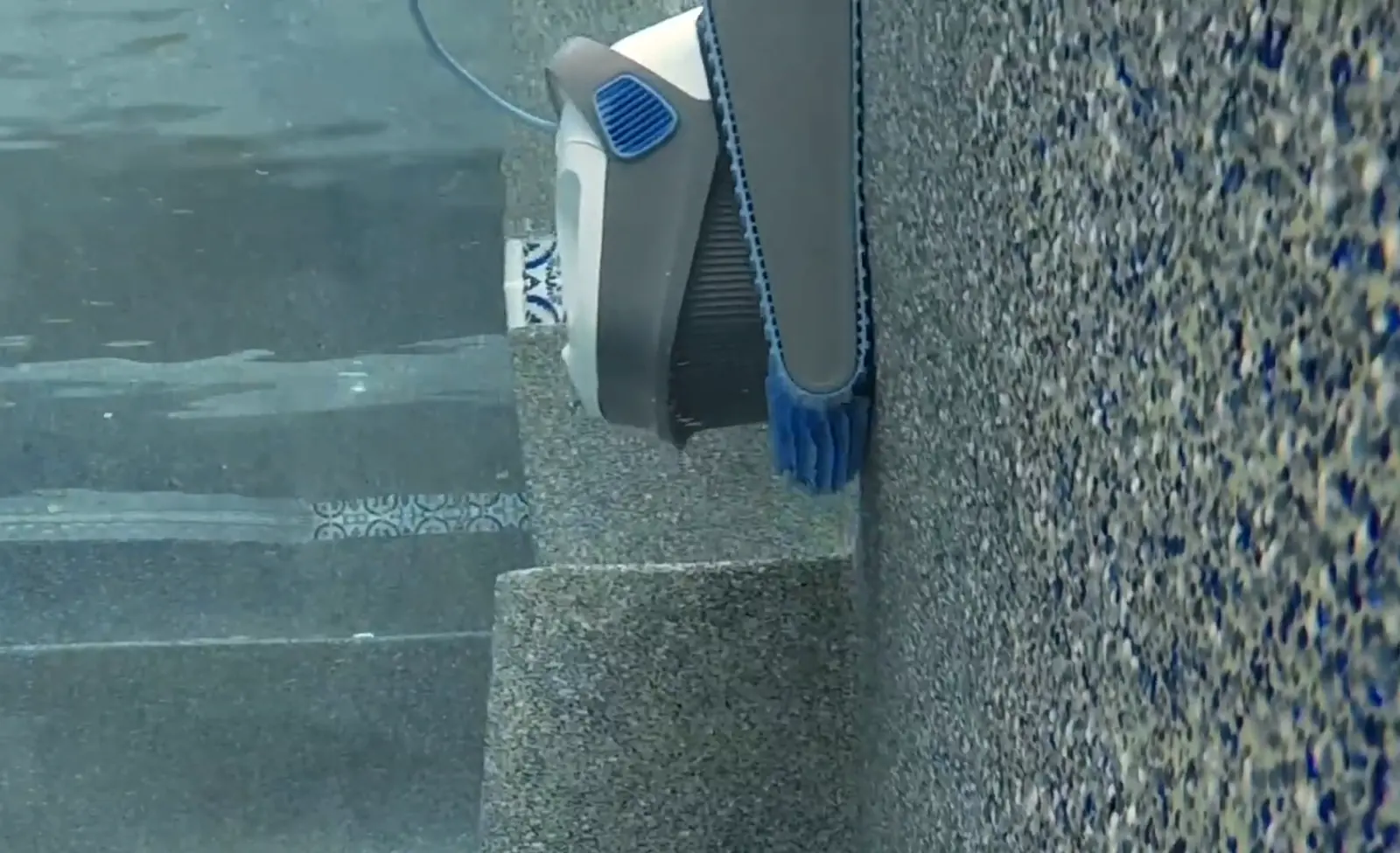 Dolphin S200 sur des marches de piscine, brosse en contact