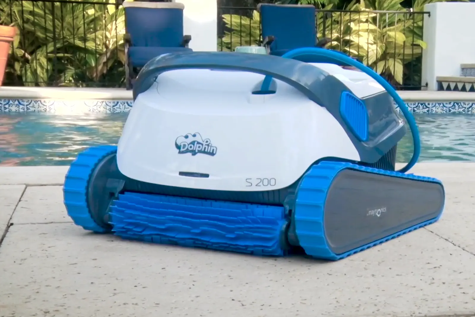 Robot de piscine Dolphin S200 posé au bord d'un bassin, vu de trois quarts
