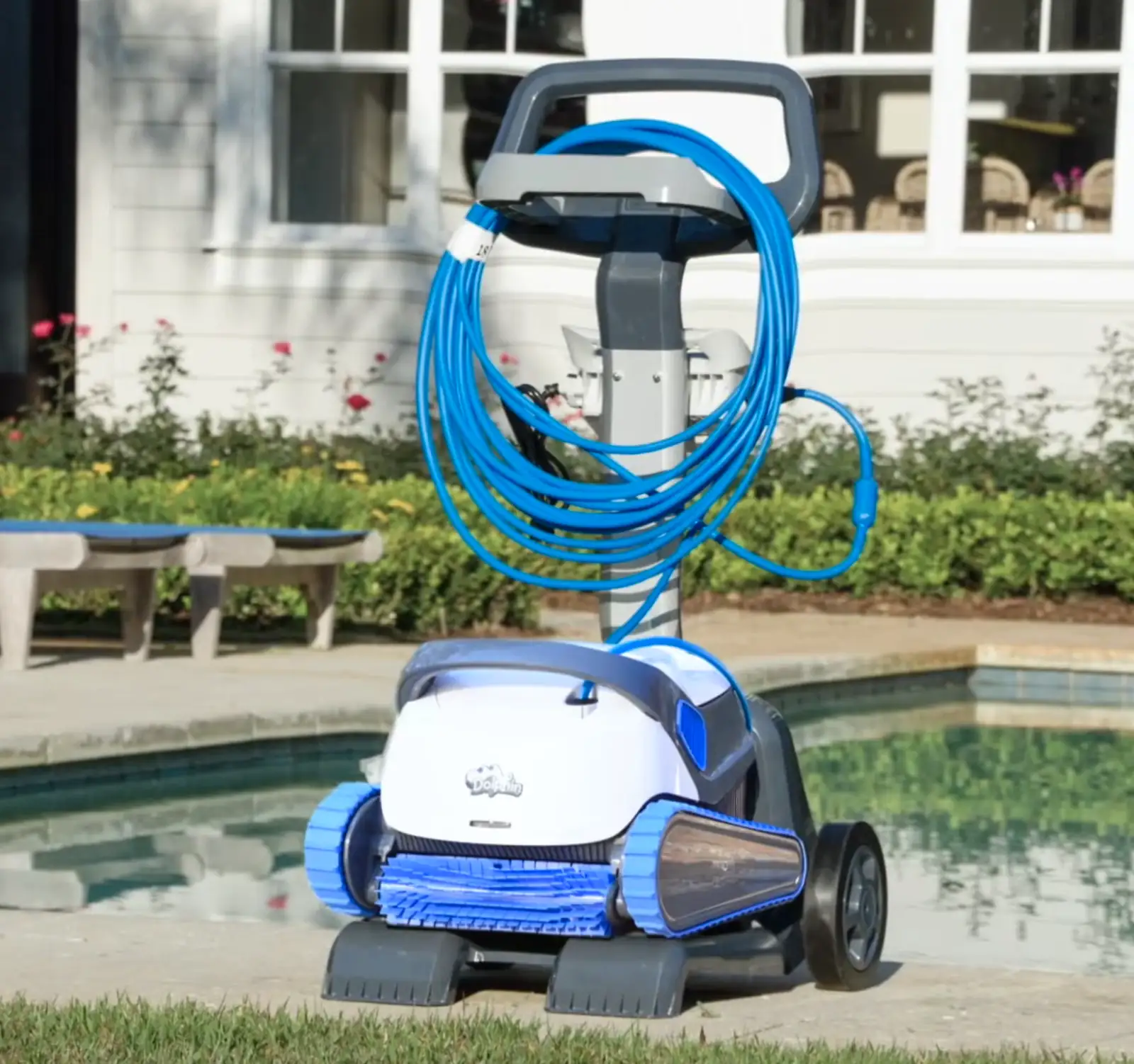 Dolphin S300 posé sur son chariot avec le câble enroulé, au bord d'une piscine