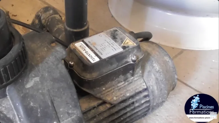 Pompe de filtration de piscine dans un local technique, bornier électrique sur le moteur