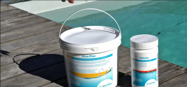 Seau de correcteur d'alcalinité et pot de chlore choc posés au bord d'une piscine
