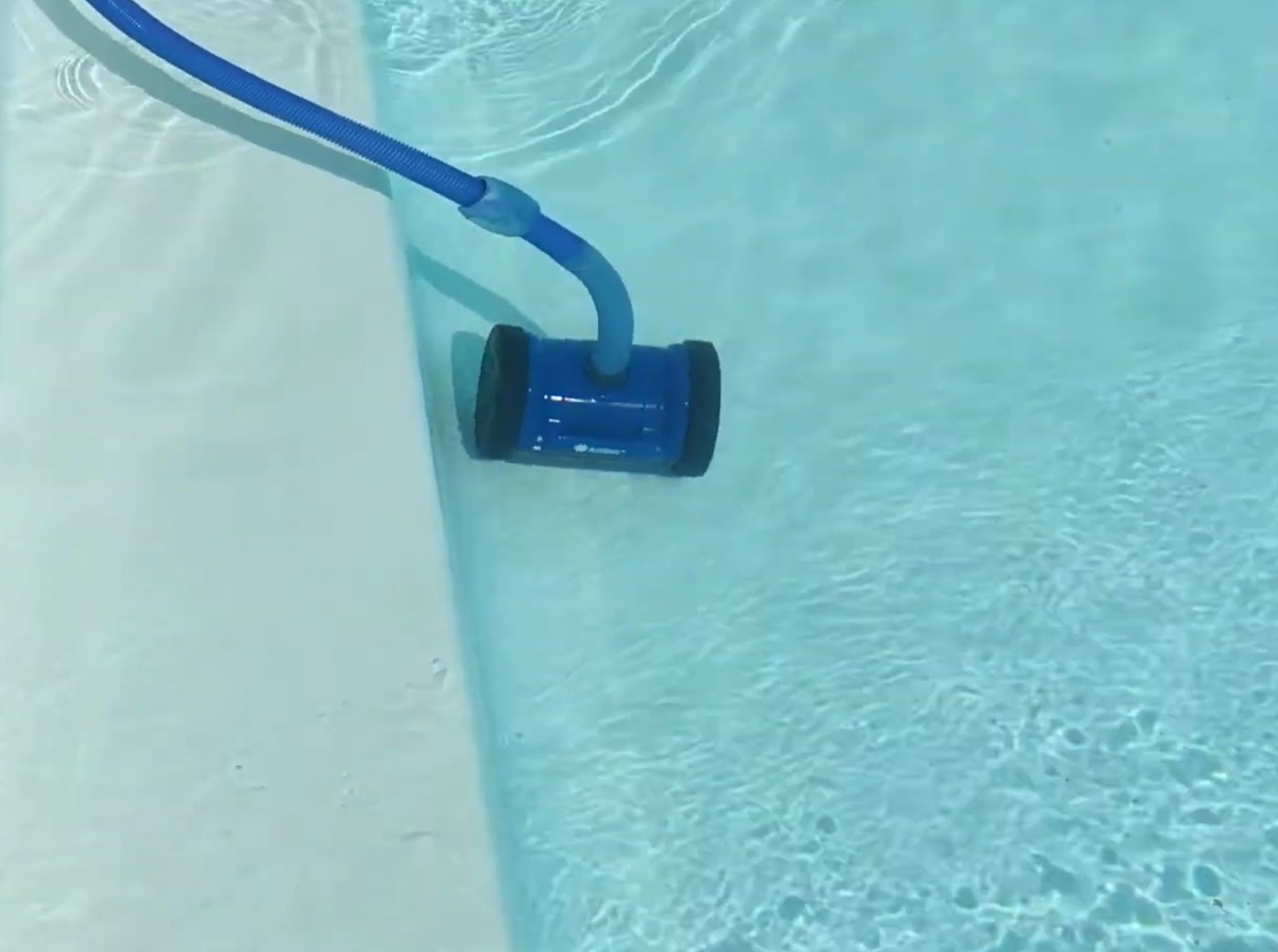Robot hydraulique collé à la paroi verticale d'une piscine en liner